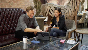 Two people collaborating over a tablet at a cafe