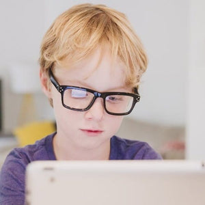 Boy with glasses using tablet (BBA8CZBZBE)