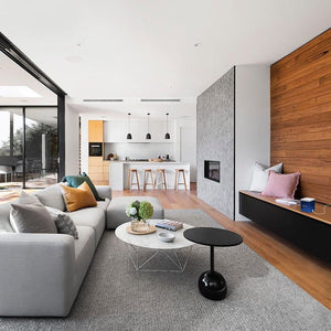 Modern living room with open kitchen and fireplace.