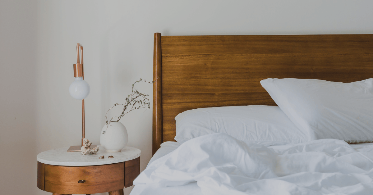Cozy bedroom with wooden headboard and white bedding for a good night's sleep