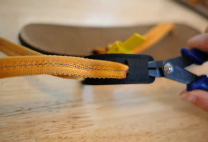Repairing sandal strap with pliers