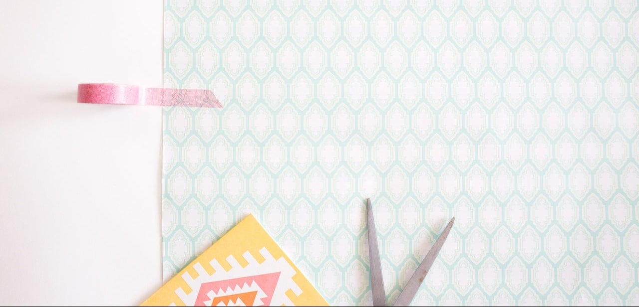 Pink tape, patterned paper, scissors, and design elements.