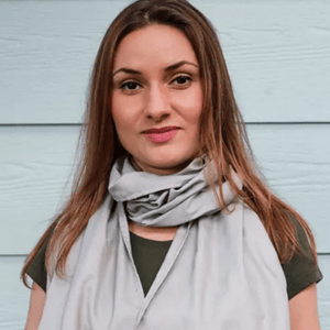 Woman wearing grey scarf, smiling