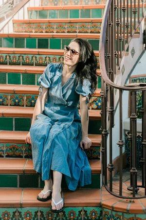 Woman in dress on stairs, wearing beach sandals
