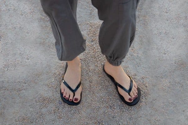 Black grounding flip flops on feet
