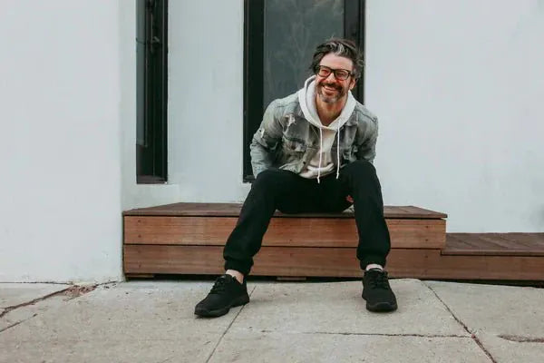 Man wearing black grounding sneakers, lifestyle shot.