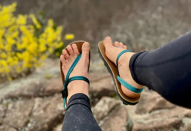 Feet wearing sandals with blue straps.