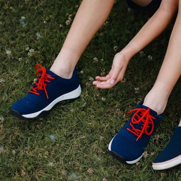 Navy bamboo knit sneakers with red laces, lifestyle shot