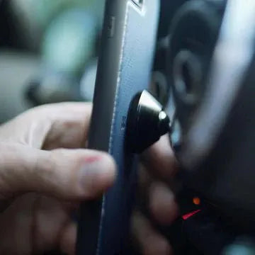 Adhesive phone case style in use, with car dashboard visible.