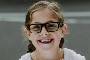 Bailey smiling in retro tortoise eyeglasses
