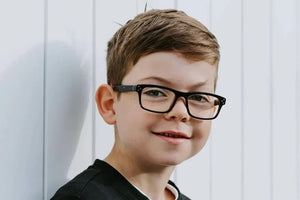 Bailey wearing retro tortoise glasses, smiling