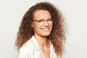 Woman smiling, wearing crystal eyeglasses