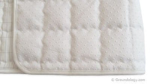 Quilted pad detail, white with textured surface.